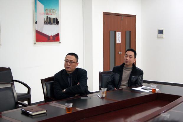 图5、欧博ABG抛光砖销售副总张彦（左一）、欧博ABG广东线销售副总庞永江（右一）认真寓目参评专卖店幻灯片播放效果