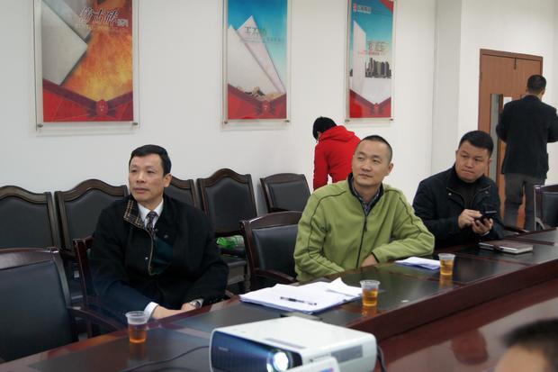 图6、寓目幻灯片的同时，，，欧博ABG仿古砖副总曹坚贞（右一）特殊用手机记下专卖店装修效果的差别亮点